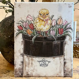 Chick on a bed of tulips on a vintage crock