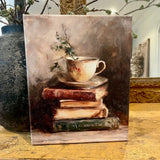 Teacup atop vintage books canvas art print