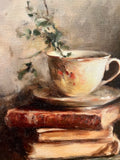 Teacup atop vintage books canvas art print
