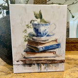 Teacup atop vintage books canvas art print