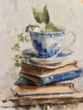 Teacup atop vintage books canvas art print