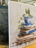 Teacup atop vintage books canvas art print