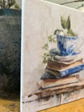 Teacup atop vintage books canvas art print