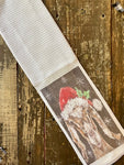 close up brown and white goat wearing santa hat hand towel